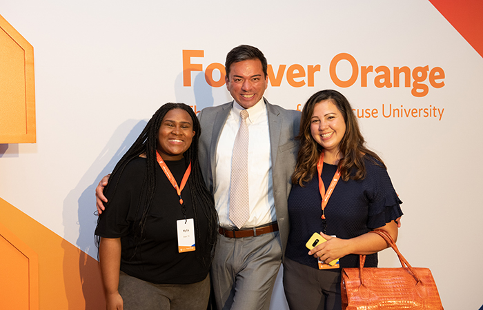 Guests pose for a photo with the campaign backdrop.